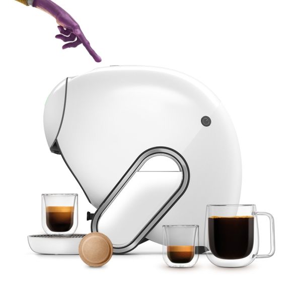 Dedo de un alienígena tocando la cafetera NEO Caffè. Bebidas NEO y una cápsula hecha a base de papel.