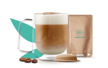 Café con leche en una taza junto a un sobre de papel