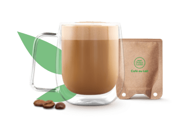 Caf&eacute; con leche en una taza junto a un sobre de papel