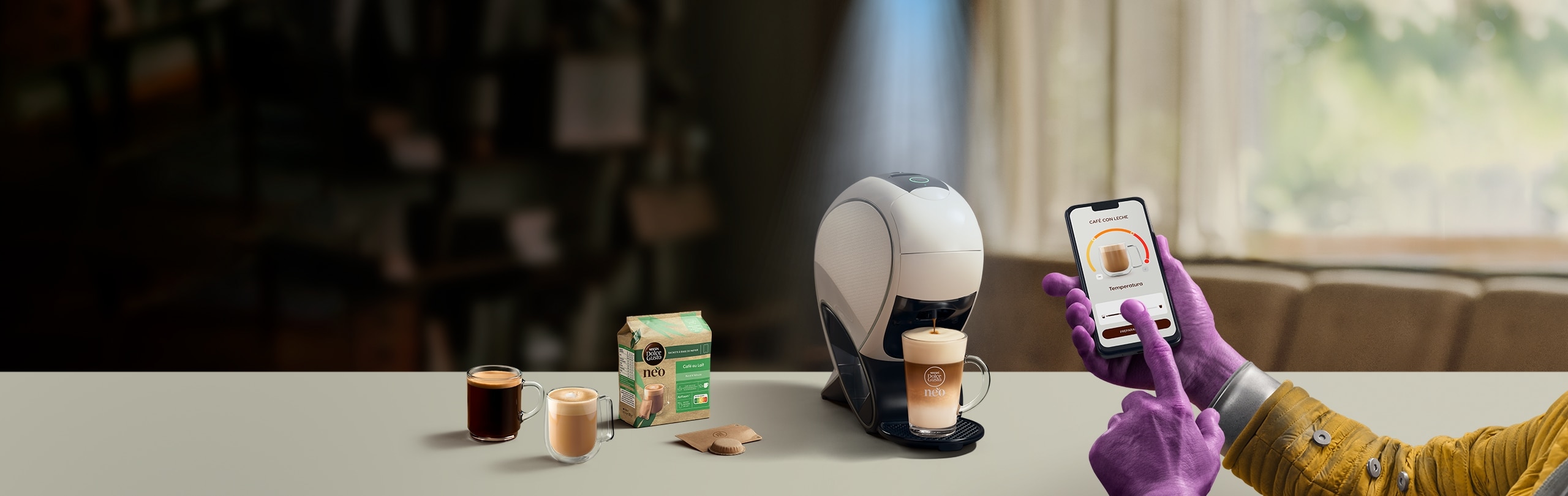 Una mano alienígena utilizando la aplicación NESCAFÉ Dolce Gusto para personalizar una bebida. Cafetera inteligente NEO Latte, pack de café y bebidas.