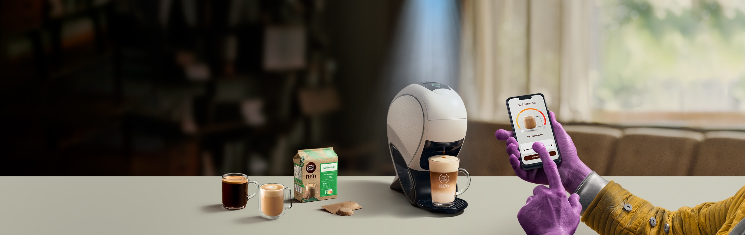 Una mano alienígena utilizando la aplicación NESCAFÉ Dolce Gusto para personalizar una bebida. Cafetera inteligente NEO Latte, pack de café y bebidas.