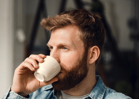 hombre bebe una taza de café
