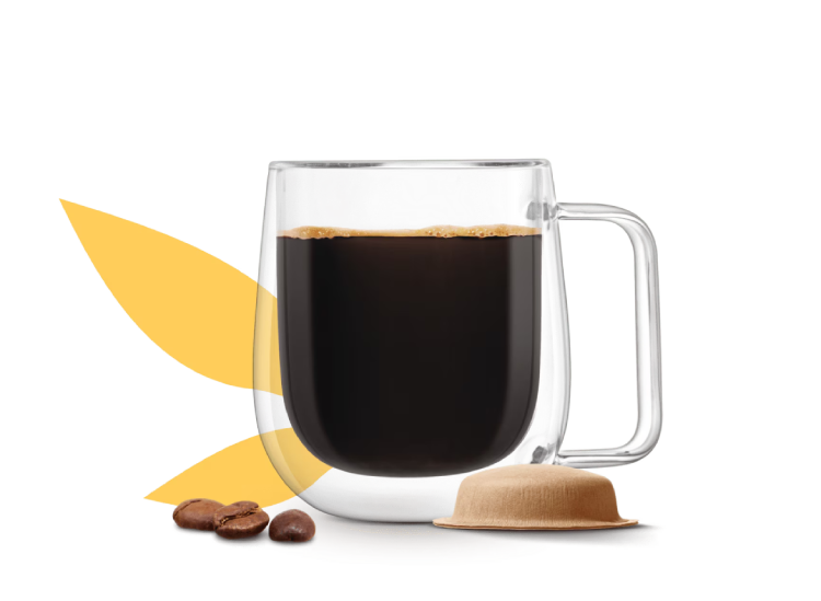 Taza de café junto a una cápsula a base de papel